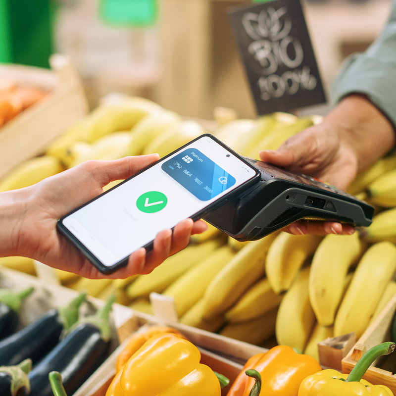 shutterstock_2412962899-img Digital banking concept shopper using cellphone with contactless payment technology to pay for