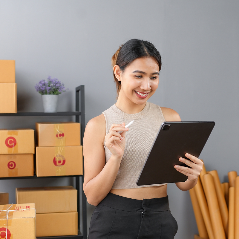 Smiling girl holding a tablet device and looking at the screen
