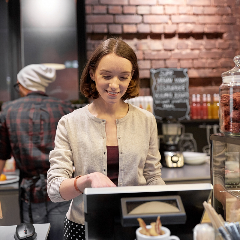 shutterstock_647805454-img Small business people and service concept happy woman or barmaid at counter with cashbox working