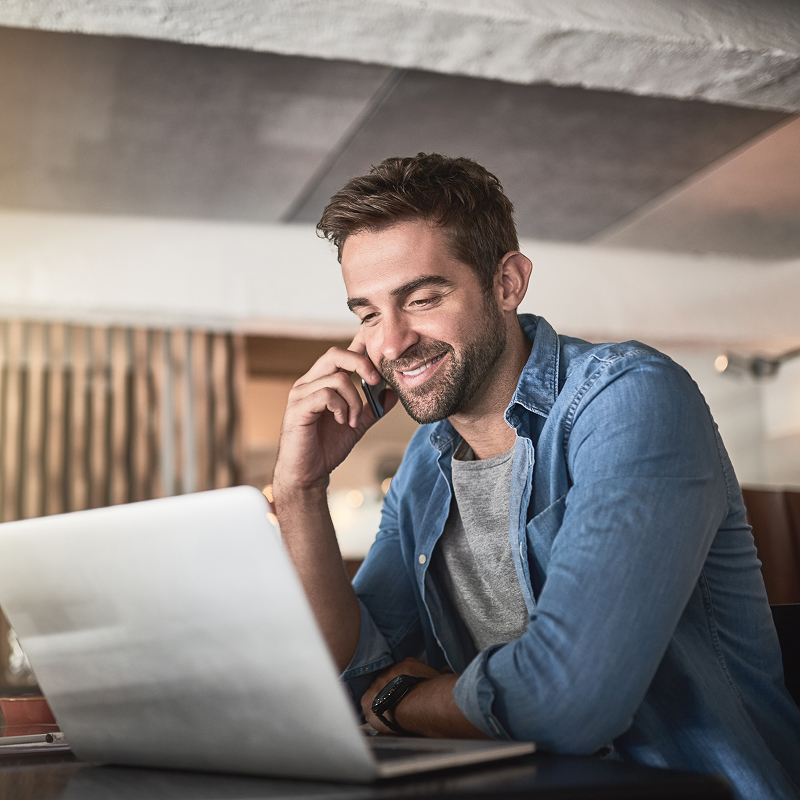shutterstock_2129383844-img Customer support smiling man using laptop talking on phone with call center operator at home free